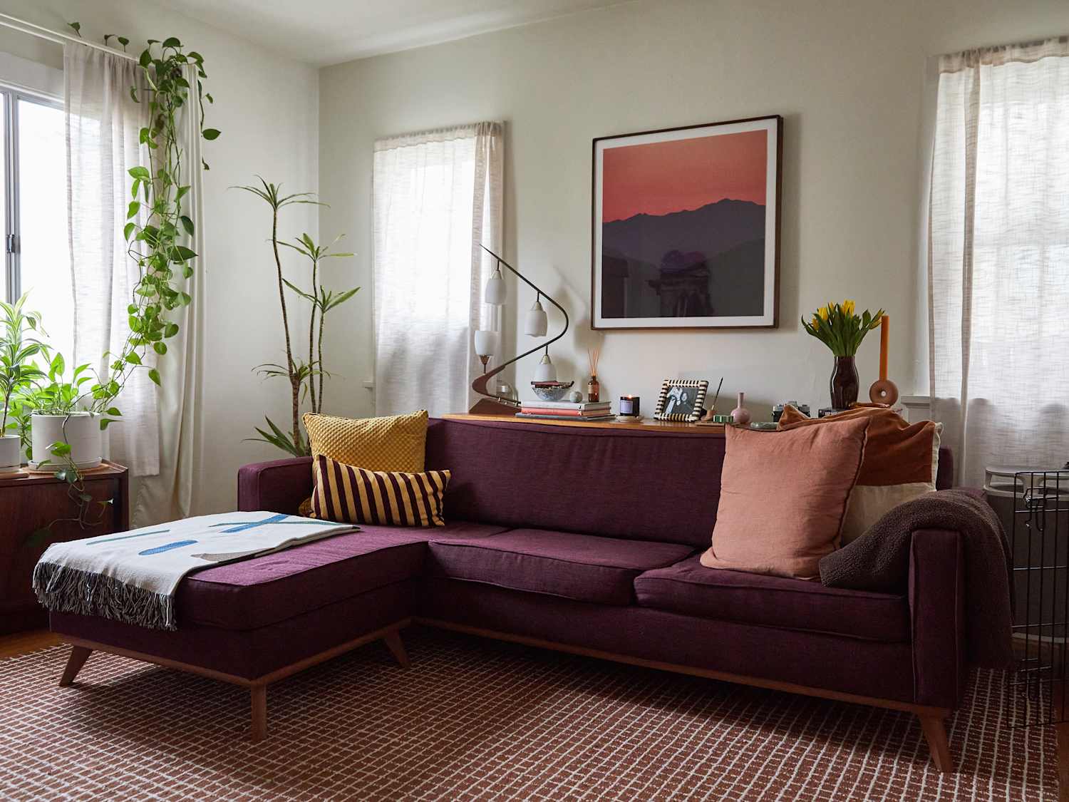 Warm, inviting therapy space with purple sofa, plants, and art